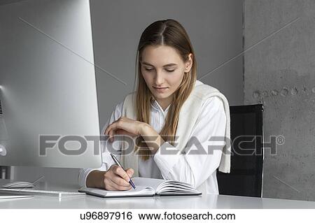 Businesswoman writing in notebook View Large Photo Image Stock Photograph - Businesswoman writing in notebook. Fotosearch