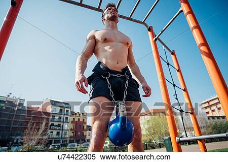 Calisthenics at outdoor gym, bare chested young man standing with kettlebell on waist harness View Large Photo Image Stock Photography - Calisthenics at outdoor gym, bare chested young man standing with kettlebell on waist harness. Fotosearch