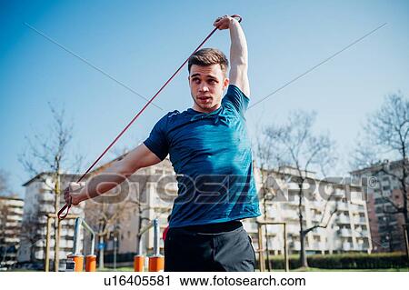 Calisthenics at outdoor gym, young man stretching resistance band View Large Photo Image Stock Image - Calisthenics at outdoor gym, young man stretching resistance band. Fotosearch