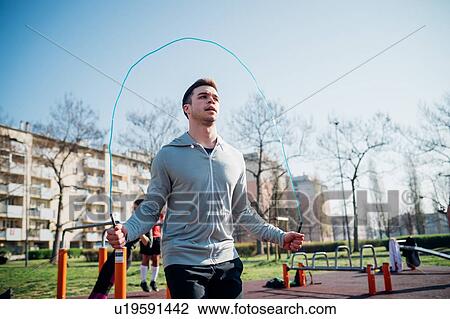Stock Image - Calisthenics at outdoor gym, young man skipping. Fotosearch