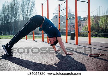 Calisthenics at outdoor gym, young man in downward dog yoga pose View Large Photo Image Stock Image - Calisthenics at outdoor gym, young man in downward dog yoga pose. Fotosearch