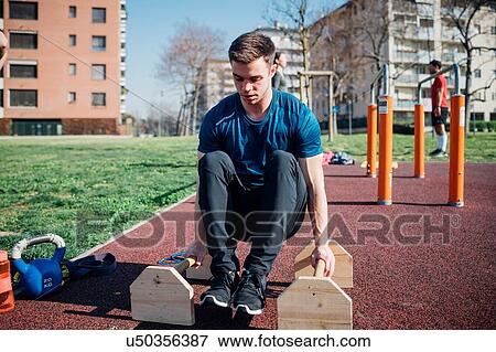 Stock Photo - Calisthenics at outdoor gym, young man doing push ups. Fotosearch