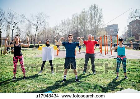 Calisthenics class at outdoor gym, women and men flexing their arm muscles View Large Photo Image Picture - Calisthenics class at outdoor gym, women and men flexing their arm muscles. Fotosearch