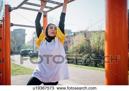 Calisthenics class at outdoor gym, young woman hanging from exercise equipment View Large Photo Image Stock Image - Calisthenics class at outdoor gym, young woman hanging from exercise equipment. Fotosearch