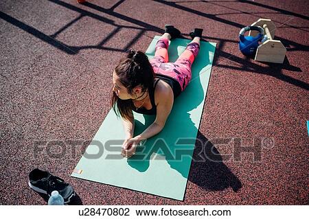 Calisthenics class at outdoor gym, young woman taking a break on yoga mat View Large Photo Image Stock Image - Calisthenics class at outdoor gym, young woman taking a break on yoga mat. Fotosearch