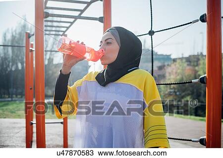 Calisthenics class at outdoor gym, young woman drinking from water bottle View Large Photo Image Stock Image - Calisthenics class at outdoor gym, young woman drinking from water bottle. Fotosearch