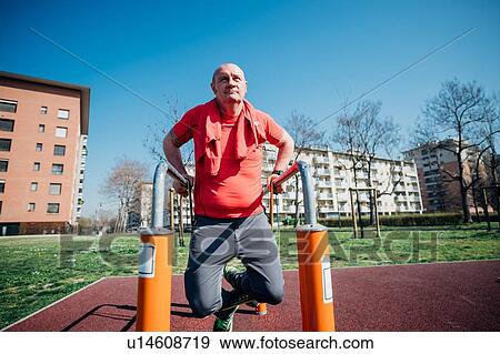 Calisthenics class at outdoor gym, mature man doing push ups on parallel bars View Large Photo Image Stock Photo - Calisthenics class at outdoor gym, mature man doing push ups on parallel bars. Fotosearch