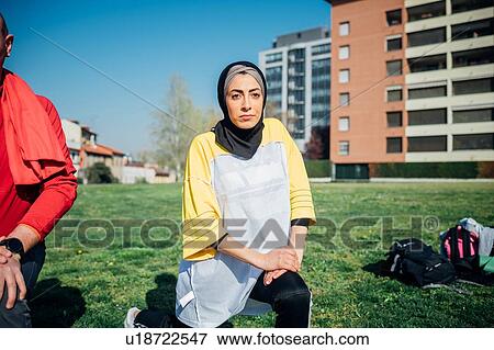 Stock Photo - Calisthenics class at outdoor gym, young woman and man practicing warrior yoga position. Fotosearch