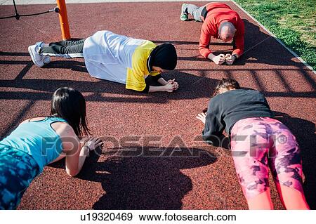 Stock Photo - Calisthenics class at outdoor gym, young women and man practicing yoga position. Fotosearch