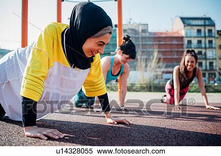 Stock Photography - Calisthenics class at outdoor gym, young women practicing yoga position. Fotosearch