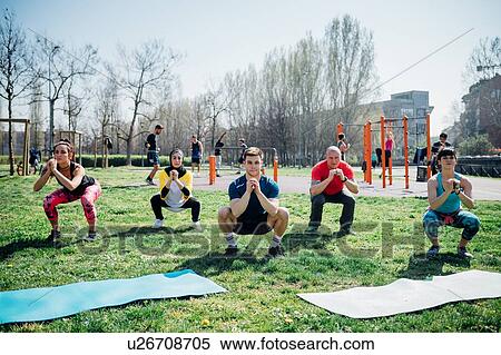 Calisthenics class at outdoor gym, women and men practicing yoga squatting pose View Large Photo Image Stock Photography - Calisthenics class at outdoor gym, women and men practicing yoga squatting pose. Fotosearch