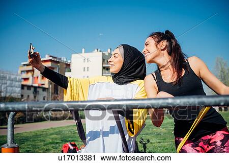 Calisthenics class at outdoor gym, two young women taking smartphone selfie View Large Photo Image Stock Image - Calisthenics class at outdoor gym, two young women taking smartphone selfie. Fotosearch