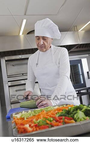 Stock Photography - Chef slicing squash in commercial kitchen. Fotosearch