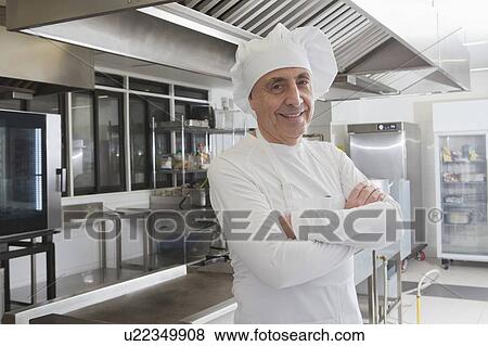 Stock Photo - Chef smiling in commercial kitchen. Fotosearch