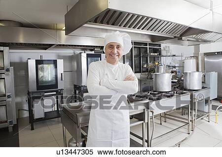 Stock Photography - Chef smiling in commercial kitchen. Fotosearch
