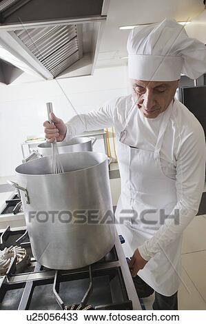 Stock Image - Chef using whisk in pot. Fotosearch