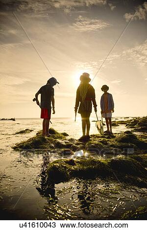 Stock Image - Children exploring tide pools in La Jolla, California. Fotosearch