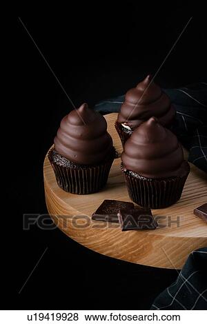 Chocolate cupcakes on wooden cutting board View Large Photo Image Stock Photo - Chocolate cupcakes on wooden cutting board. Fotosearch