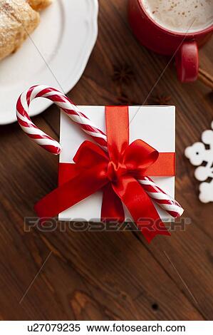 Stock Photography - Christmas present with red ribbon and candy cane. Fotosearch