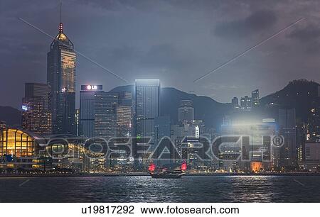 Stock Image - City skyline at sunset in Hong Kong, China. Fotosearch