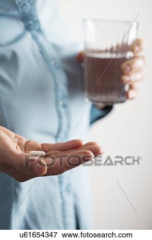 Close-up of hand with a pill and glass of water. View Large Photo Image Stock Photo - Close-up of hand with a pill and glass of water.. Fotosearch