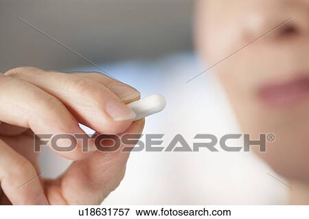 Stock Photo - Close-up of hand with a pill.. Fotosearch