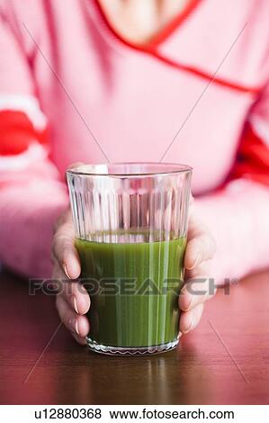 Close-up of woman holding a green juice. View Large Photo Image Stock Photo - Close-up of woman holding a green juice.. Fotosearch