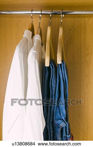 Clothes hanging in wardrobe View Large Photo Image Picture - Clothes hanging in wardrobe. Fotosearch
