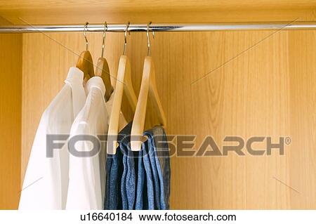 Clothes hanging in wardrobe View Large Photo Image Picture - Clothes hanging in wardrobe. Fotosearch