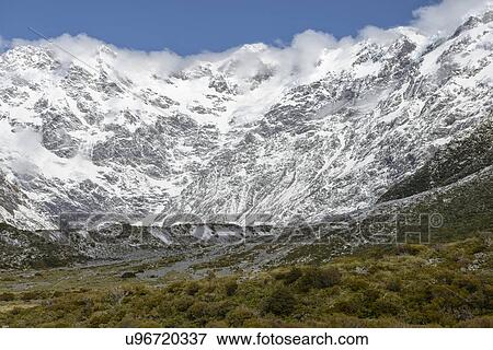 Stock Photo - Cloud over snowcapped mountains in Mount Cook National Park, New Zealand. Fotosearch