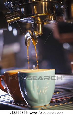 Stock Photograph - Coffee pouring from portafilter into coffee cups. Fotosearch