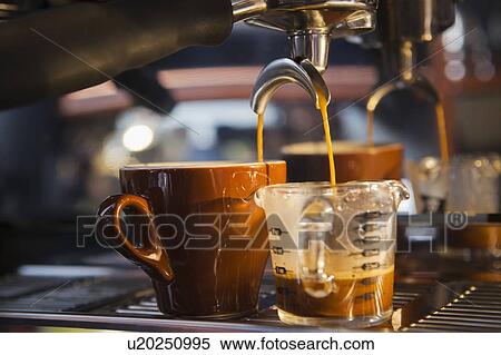 Stock Photography - Coffee pouring from portafilter into coffee cup and beaker. Fotosearch