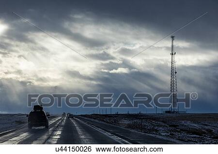Stock Photograph - Country road with snow under overcast sky. Fotosearch