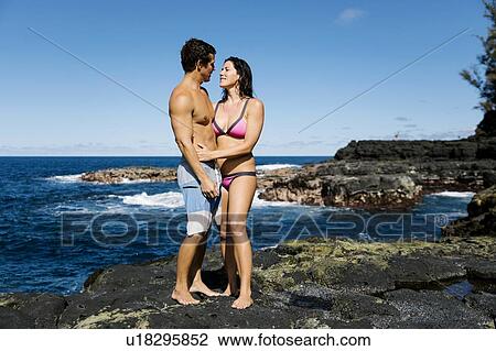 Couple embracing on rocks by sea View Large Photo Image Stock Image - Couple embracing on rocks by sea. Fotosearch