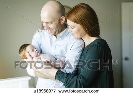 Couple holding their newborn son View Large Photo Image Stock Photo - Couple holding their newborn son. Fotosearch