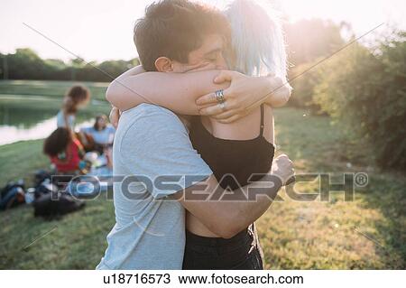 Stock Image - Couple hugging by lake. Fotosearch