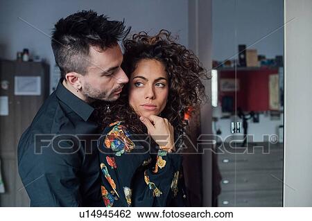 Stock Image - Couple hugging in room. Fotosearch