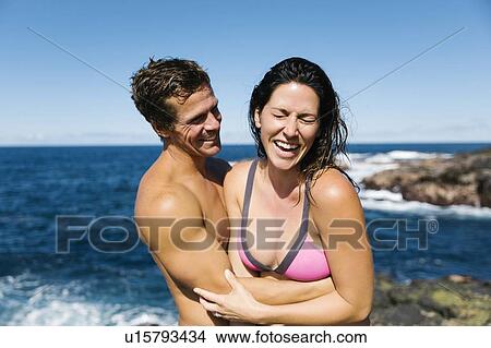 Picture - Couple laughing by sea. Fotosearch