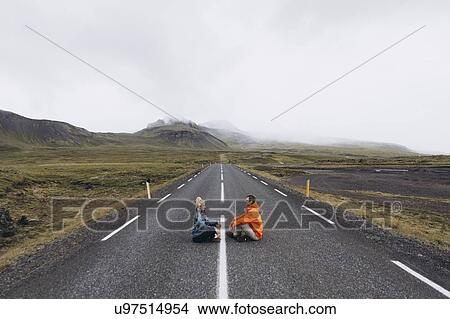 Couple sitting on highway in Iceland View Large Photo Image Picture - Couple sitting on highway in Iceland. Fotosearch