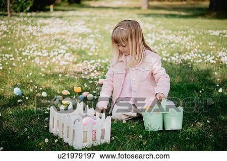 Cute girl sitting in field with easter eggs and basket, Arezzo, Tuscany, Italy View Large Photo Image Stock Photo - Cute girl sitting in field with easter eggs and basket, Arezzo, Tuscany, Italy. Fotosearch