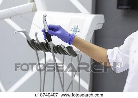 Stock Photo - Dental assistant holding dental equipment. Fotosearch