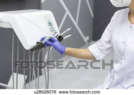 Dental assistant holding dental equipment View Large Photo Image Stock Photograph - Dental assistant holding dental equipment. Fotosearch