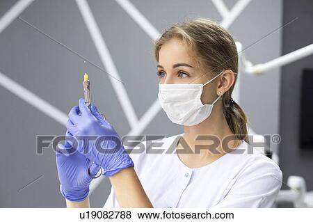 Dental assistant holding syringe View Large Photo Image Stock Photo - Dental assistant holding syringe. Fotosearch