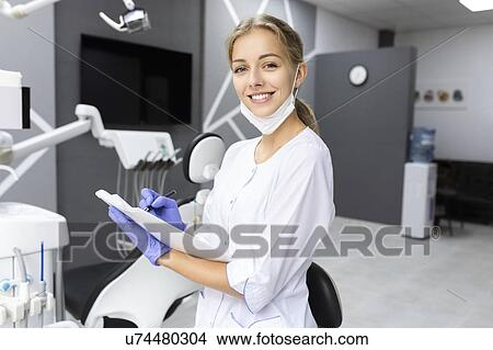 Dental assistant writing notes View Large Photo Image Picture - Dental assistant writing notes. Fotosearch