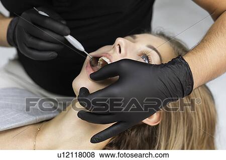 Stock Photo - Dentist examining patient. Fotosearch