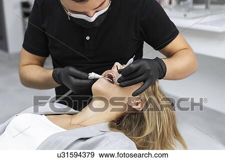 Stock Photo - Dentist examining patient. Fotosearch