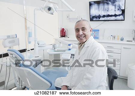 Stock Photo - Dentist smiling in dentist's surgery. Fotosearch