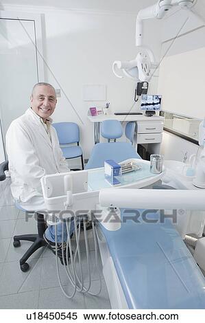 Stock Photography - Dentist smiling in dentist's surgery. Fotosearch