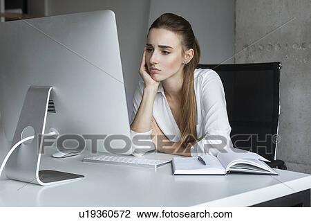 Depressed businesswoman working at desktop computer View Large Photo Image Stock Image - Depressed businesswoman working at desktop computer. Fotosearch