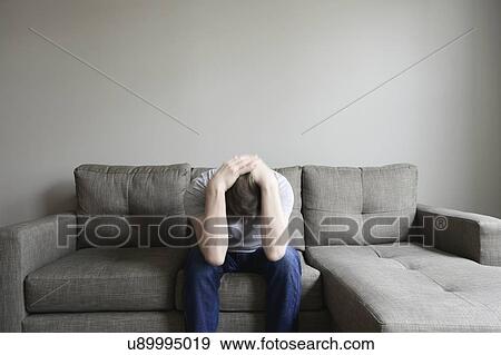 Stock Photo - Depressed mature man sitting on couch. Fotosearch